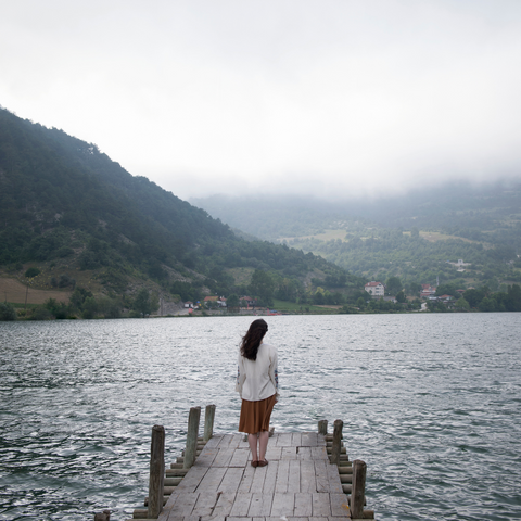 lady standing on the dock looking at the lake