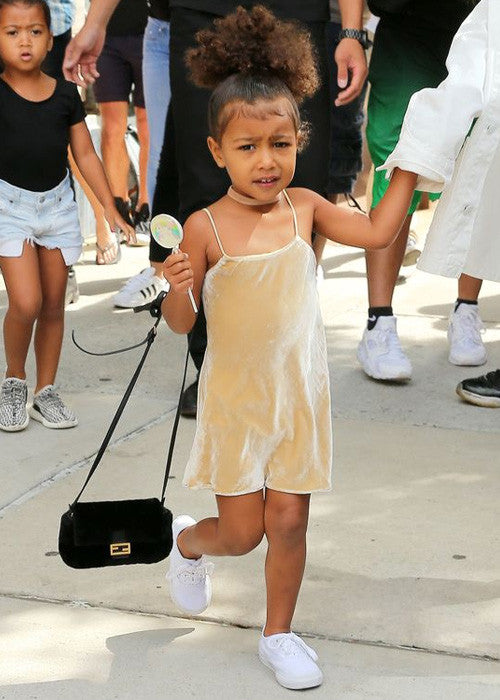 north west in a gold slip dress