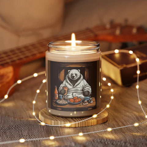 lit glass jar candle resting on a wooden trivet small white fairy lights loosely coiled around the jar, the label on the jar shows a bear relaxing after a long day at the office wearing a cozy white robe surrounded by succulent snacks