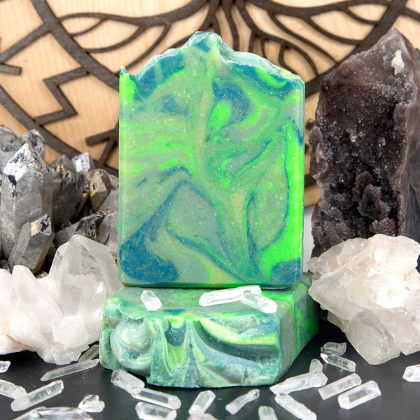 A brilliant green bar of Ragnar's Revenge handmade moisturizing soap, surrounded by crystals