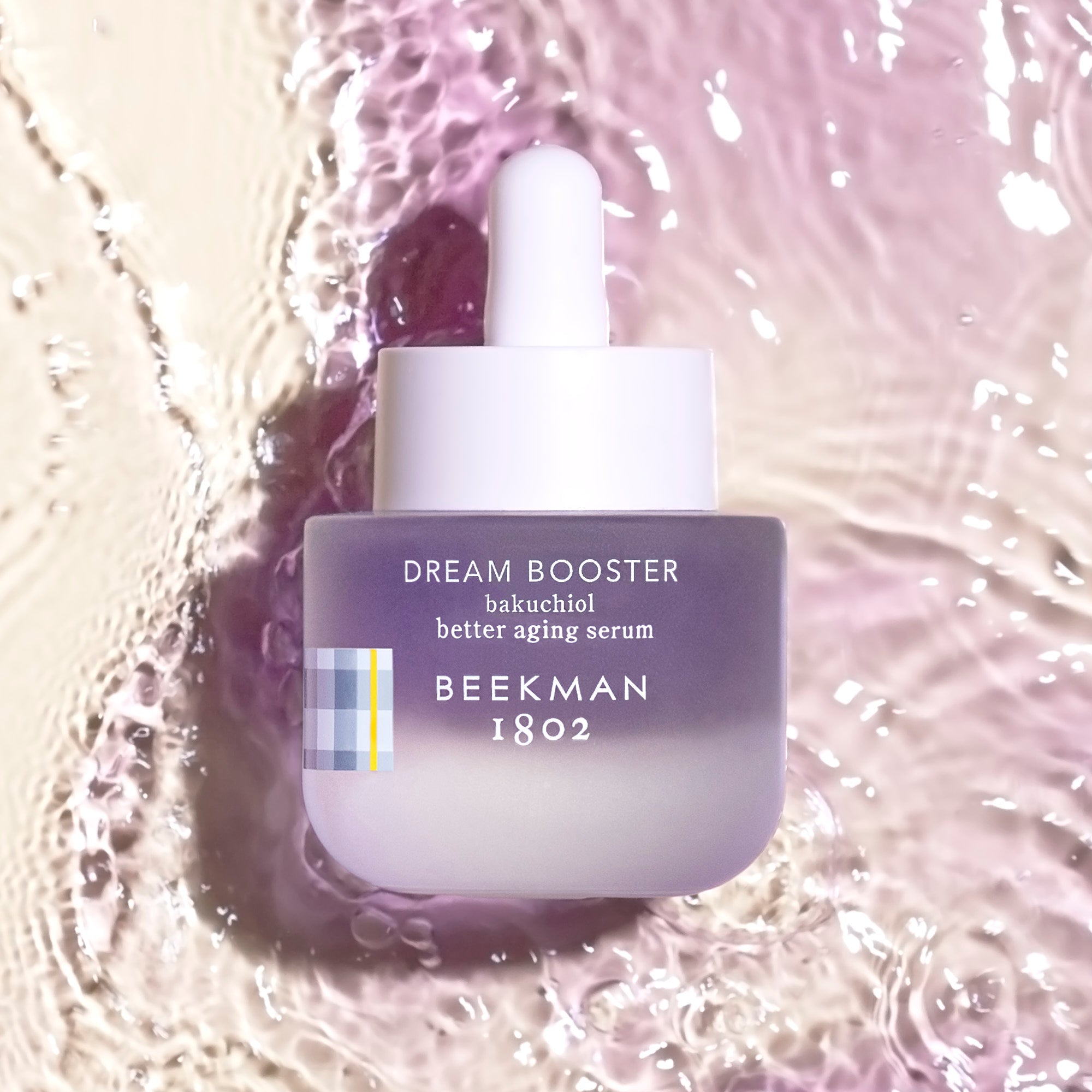 Bottle of Dream Booster Bakuchiol Serum with water ripples in the background.