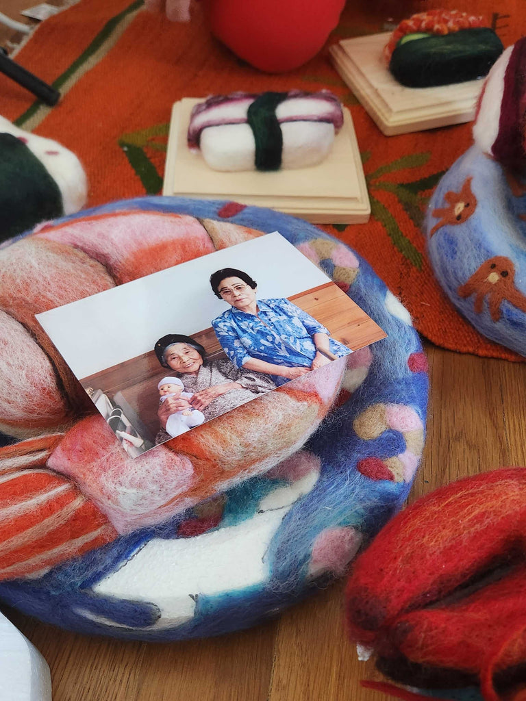 A picture of Risa's late grandmother and great aunt resting on felted pieces  of food