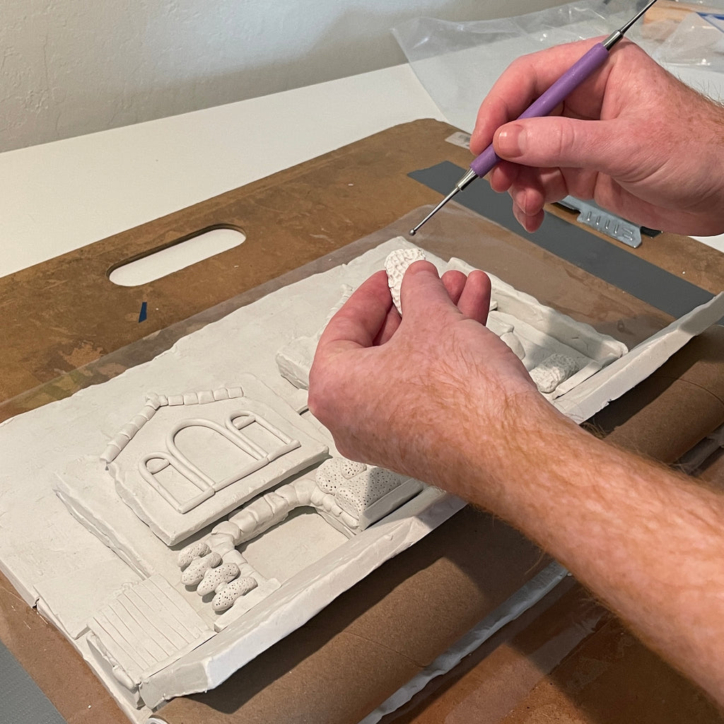 Process photo of artist Ian Mackay working on clay pieces for his show Clay Sunset .