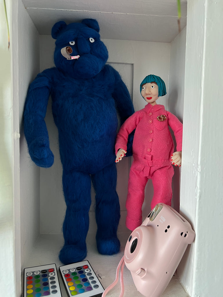 Mini replicas of Harold the puppet and Risa that sit on a shelf in her studio