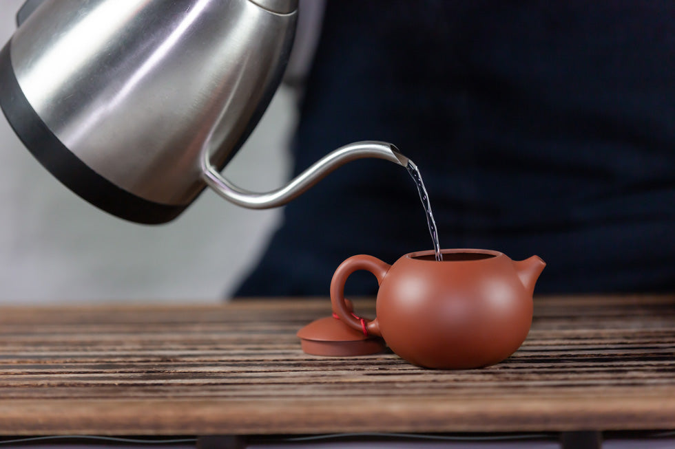 kettle pouring water in a tea pot