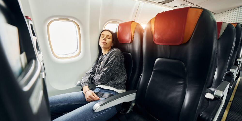 woman sleeping on airplane without a pillow