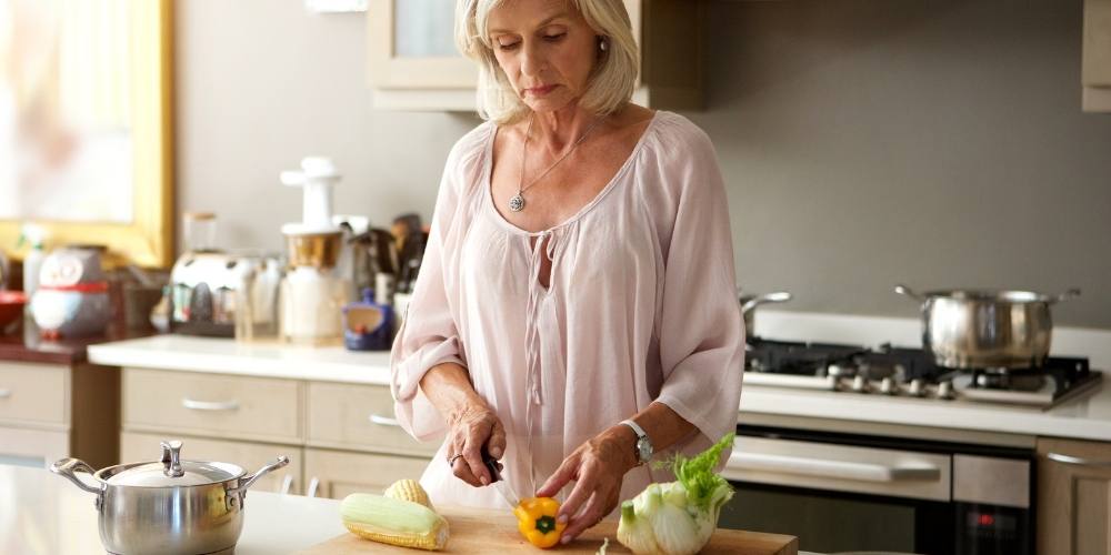 older woman cooking healthy food