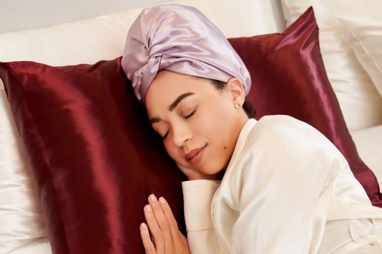 woman using silk pillowcase and head bonnet