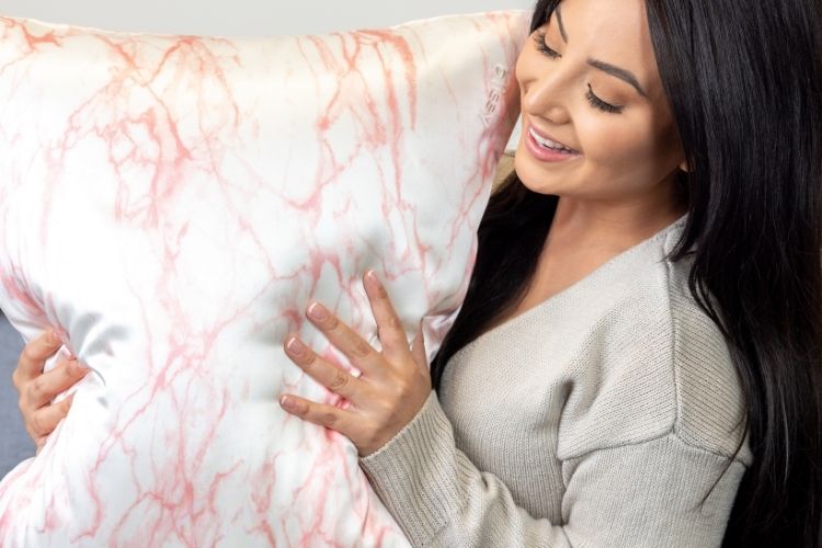 woman holding marbled patterned silk pillowcase