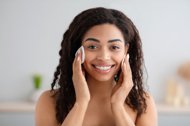 woman using a mild cleanser on a cotton pad