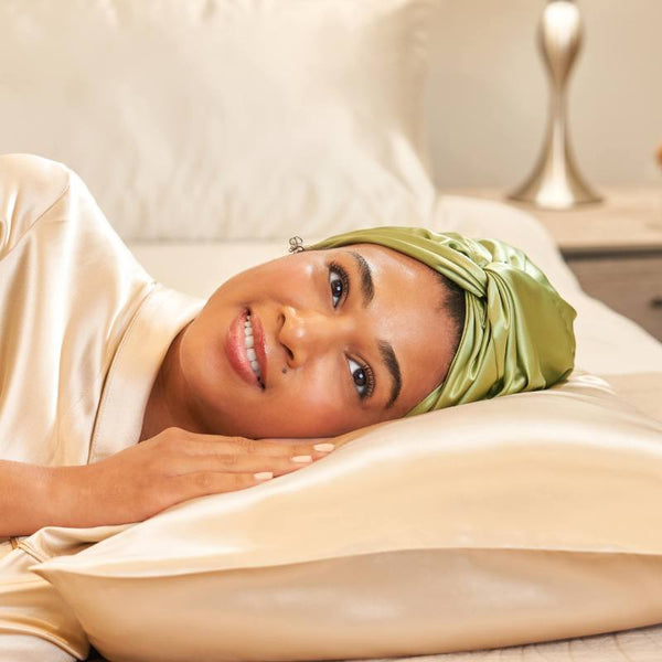 woman using hair bonnet and silk pillowcase