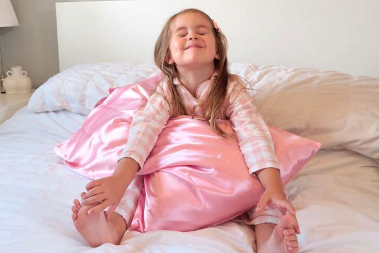 little girl with pink soft kids silk pillowcase on bed