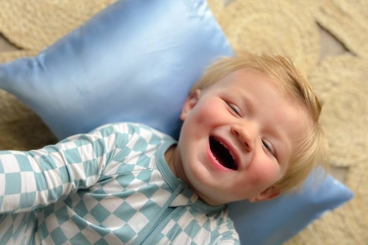 little boy with silk blue pillowcase