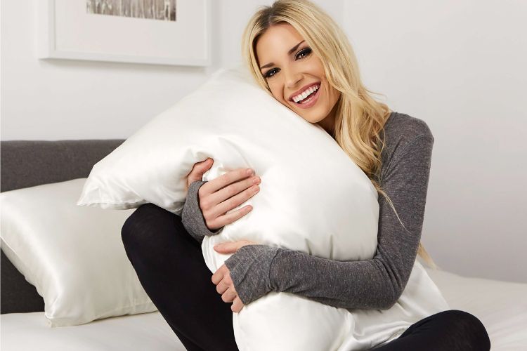 woman hugging white silk pillowcase