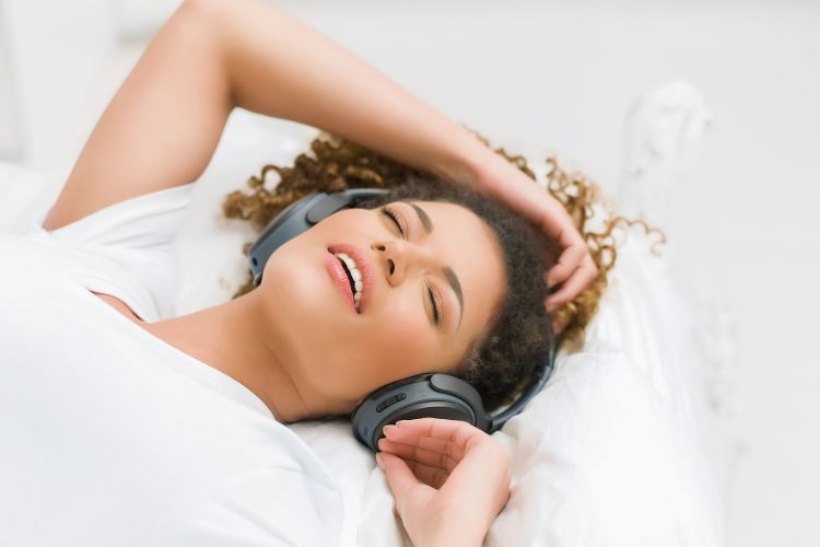 woman listening to music in bed