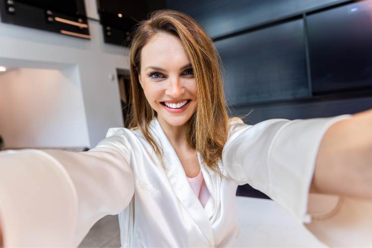 woman in white silk short robe taking selfie