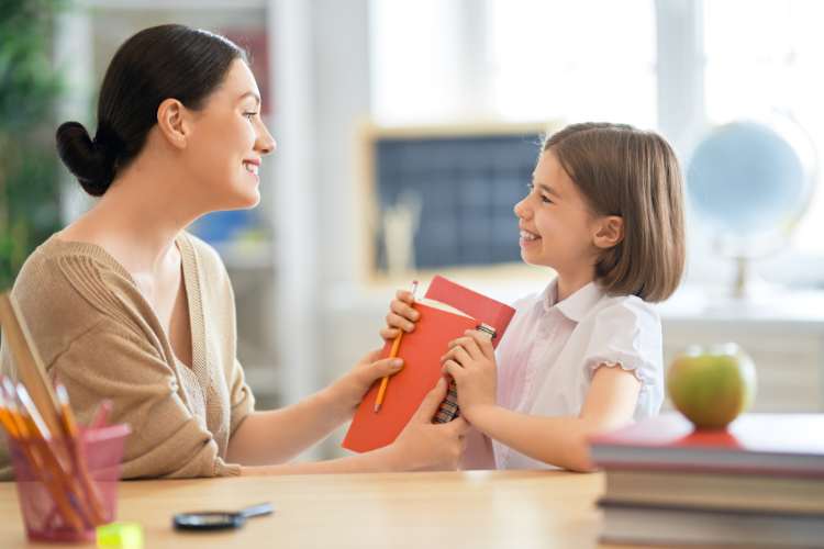 teacher helps cute little girl