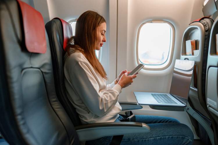 woman using devices on airplane