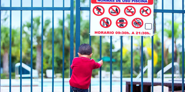 Niño frente valla para piscina metálica