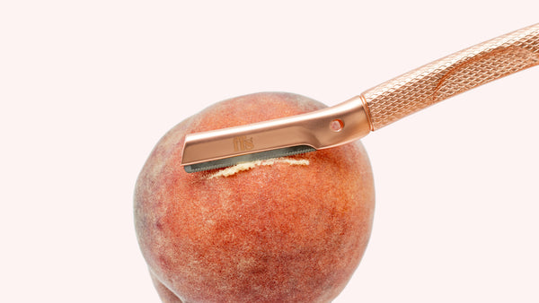A dermaplaning tool shaving "peach fuzz"