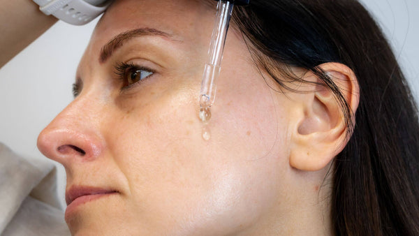 Woman moisturisers her face after dermaplaning to hydrate her skin