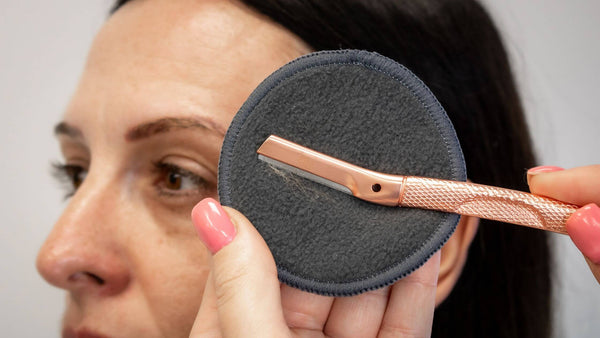 The dermaplaner is wiped with a reusable pad to keep the blade clean during use