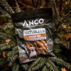A close-up of Anco chicken feet dog treats, showing the treats inside the bag.
