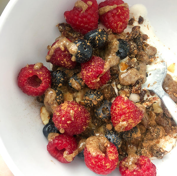 Coconut yogurt topped with berries chia seeds and almond butter