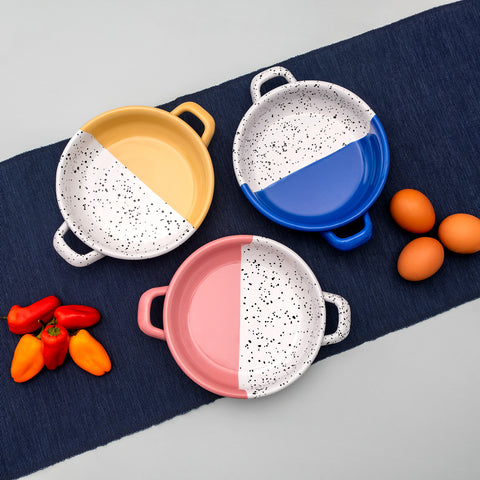Three small frying pans in blue, pink and yellow