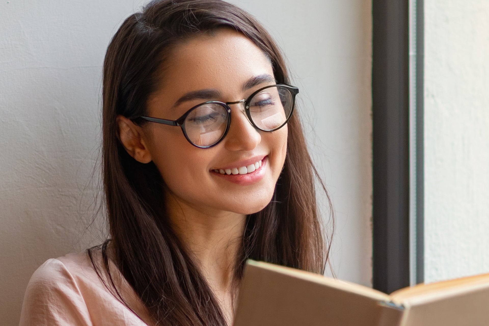 woman reading a book wearing a pair of bifocal reading glasses