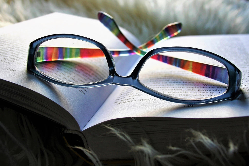 A stylish eyeglasses on top of an open book.