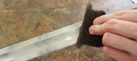 Grey scotchbrite pad used to clean blade.