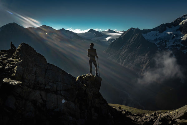 woman looking on the first sunrise light beams from sun in the alps Austria 