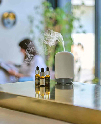 electric diffuser with fragrance oils displayed next to them