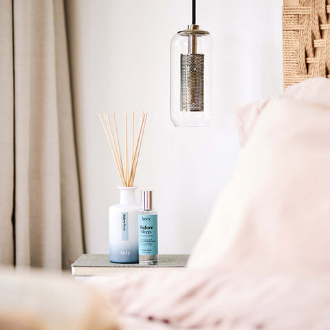 Blue before sleep reed diffuser displayed next to bed side table