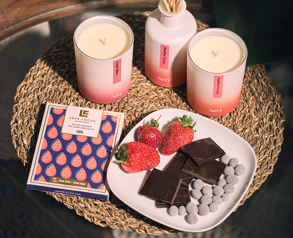 aery living candles and diffuser displayed on coffee table next to a plate of love cocoa chocolate