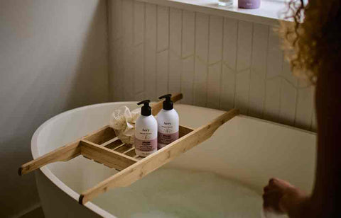 person running bath with body wash displayed on bath caddy