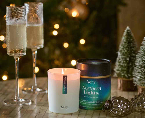 northern lights christmas candle displayed decoratively with drinks and festive decorations