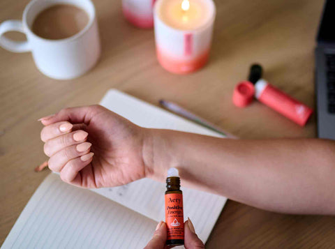 person sat at desk surrounded by aery positive energy and using a pulse point roller ball