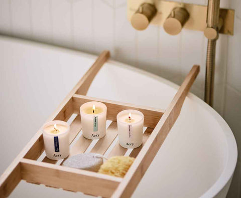 set of three votive candles in sleepy scents displayed in bathroom caddy