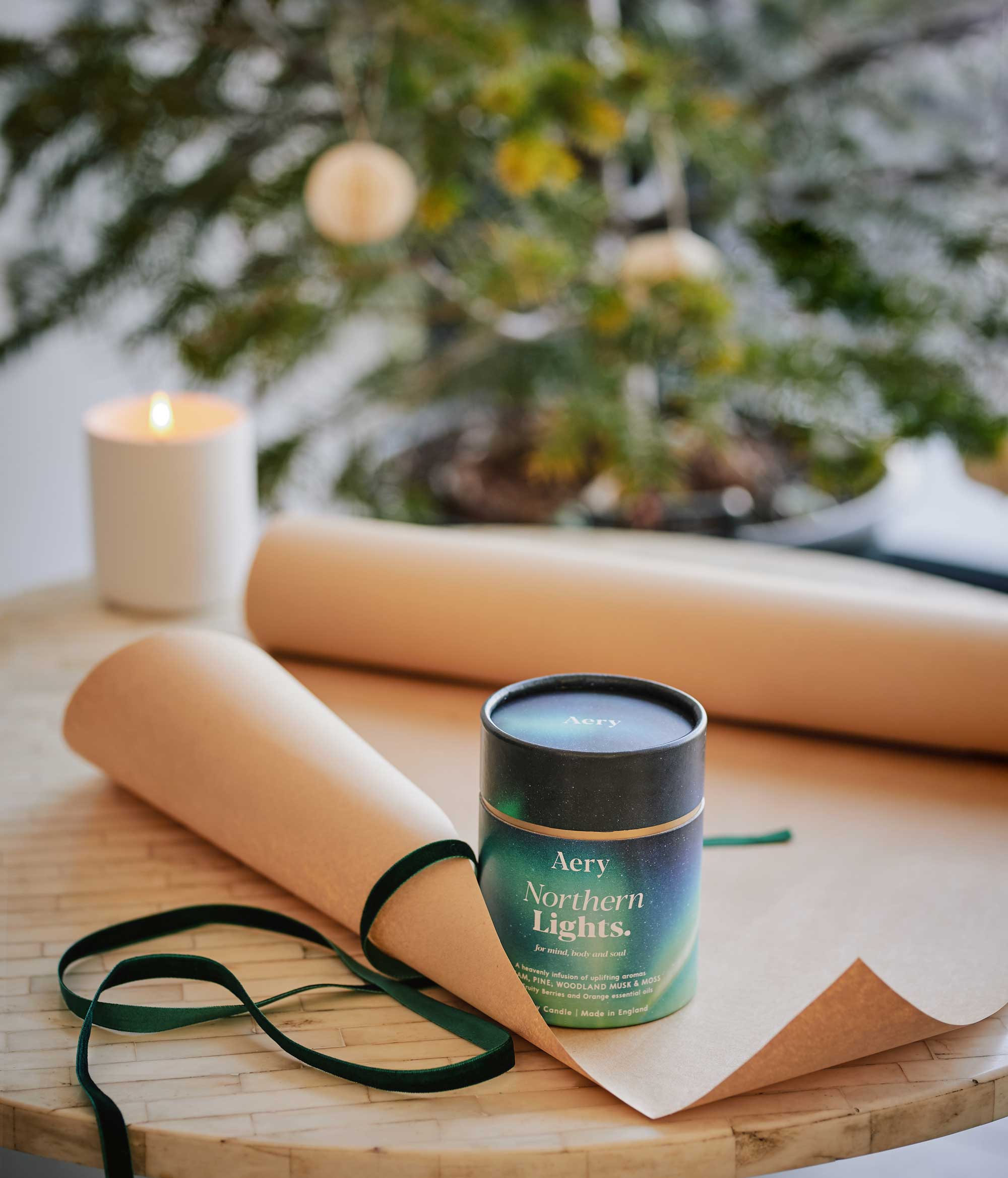 aery living northern lights scented candle in decorative product packaging displayed on a coffee table ready to be gift wrapped in front of a christmas tree