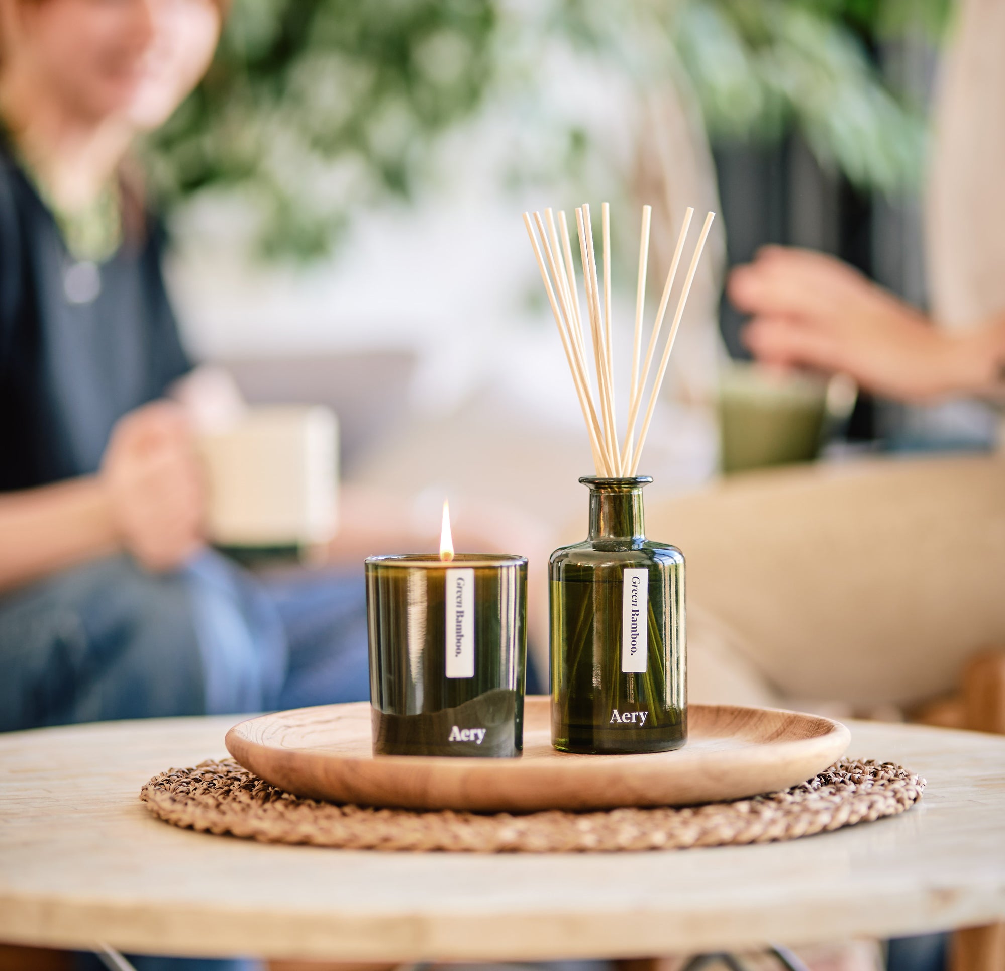 aery living green glass candle and diffuser displayed on coffee table