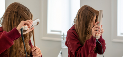 a woman with auburn colored hair dressed in a red sweatshirt styling her hair in a vanity. she is modeling how to curl hair with the tyme iron pro at a vertical and horizontal angle