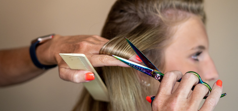 a blonde woman getting a hair trim on a studio set