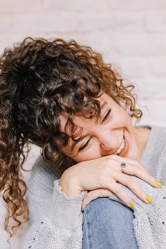 A woman with curly hair texture who is smiling.