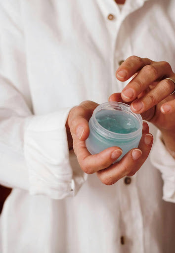 Woman holding a blue hair gel in her hand