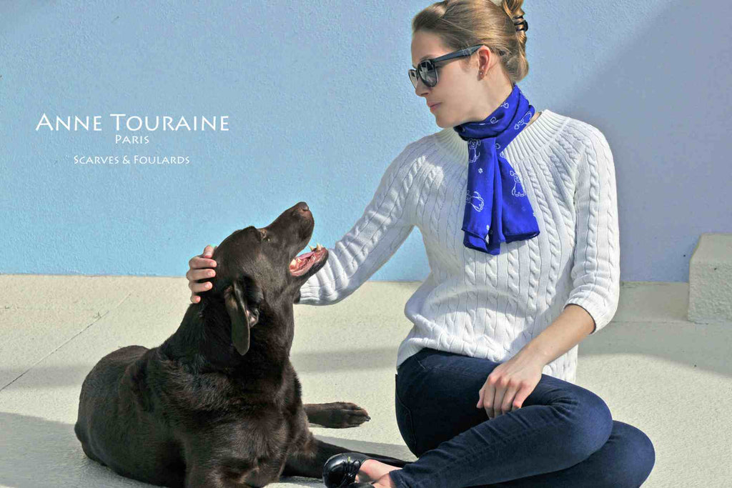 Chiffon silk scarves by ANNE TOURAINE Paris™: blue dog pattern scarf wrapped twice around the neck and tied with a tight knot