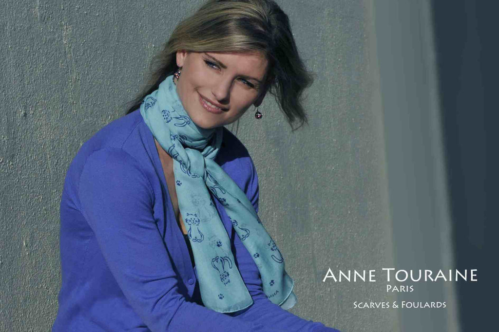Chiffon silk scarves by ANNE TOURAINE Paris™: blue cat pattern scarf wrapped twice around the neck and tied to the front 