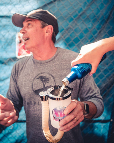 Dad having bud light poured into his kong beer bong at a tailgate