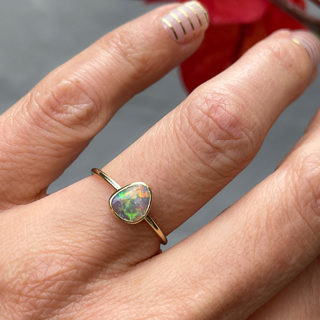 Shot on hand of dainty opal ring in 14k gold by NIXIN Jewelry